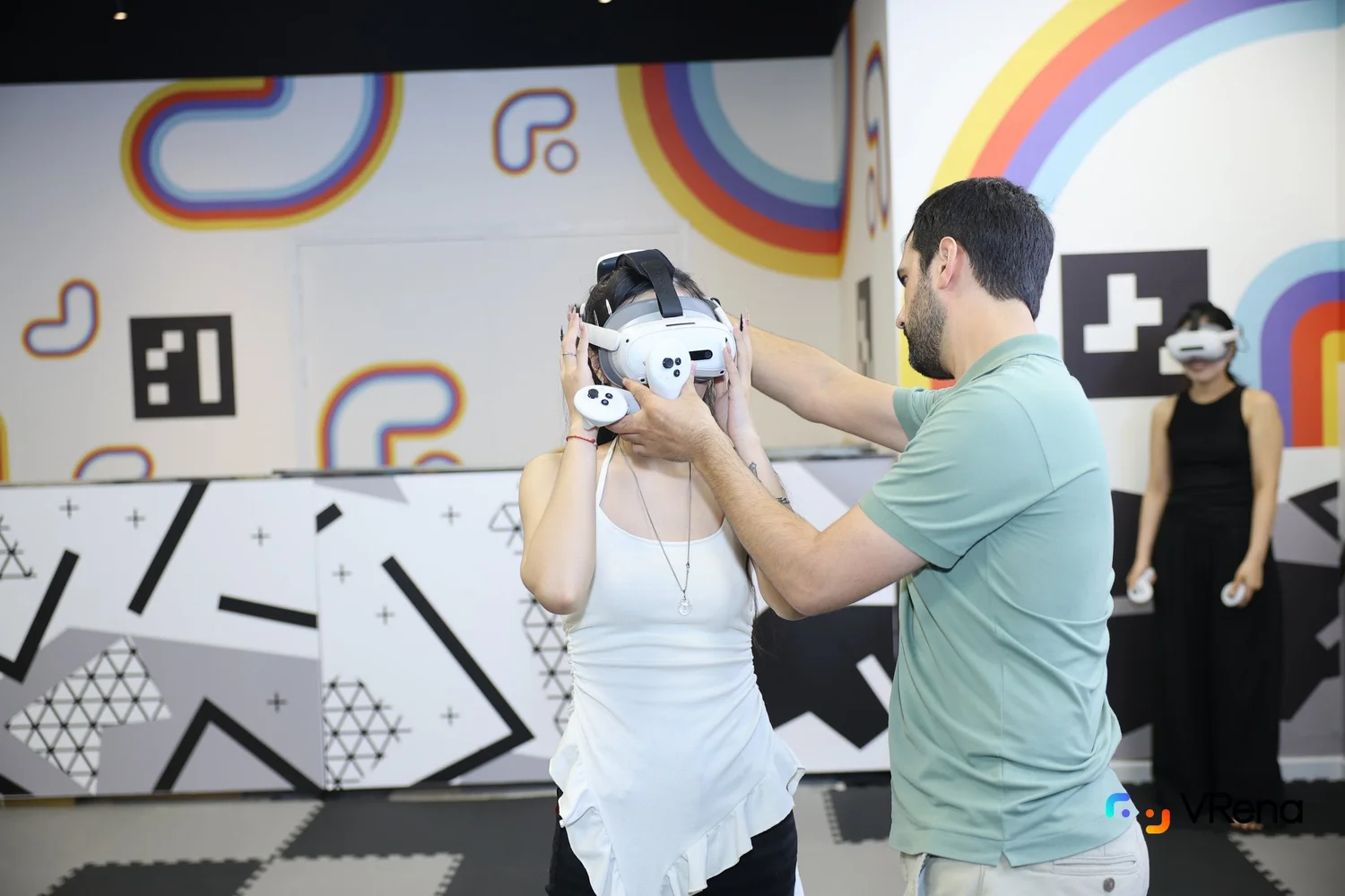 VRena team member helping a guest put on a VR headset